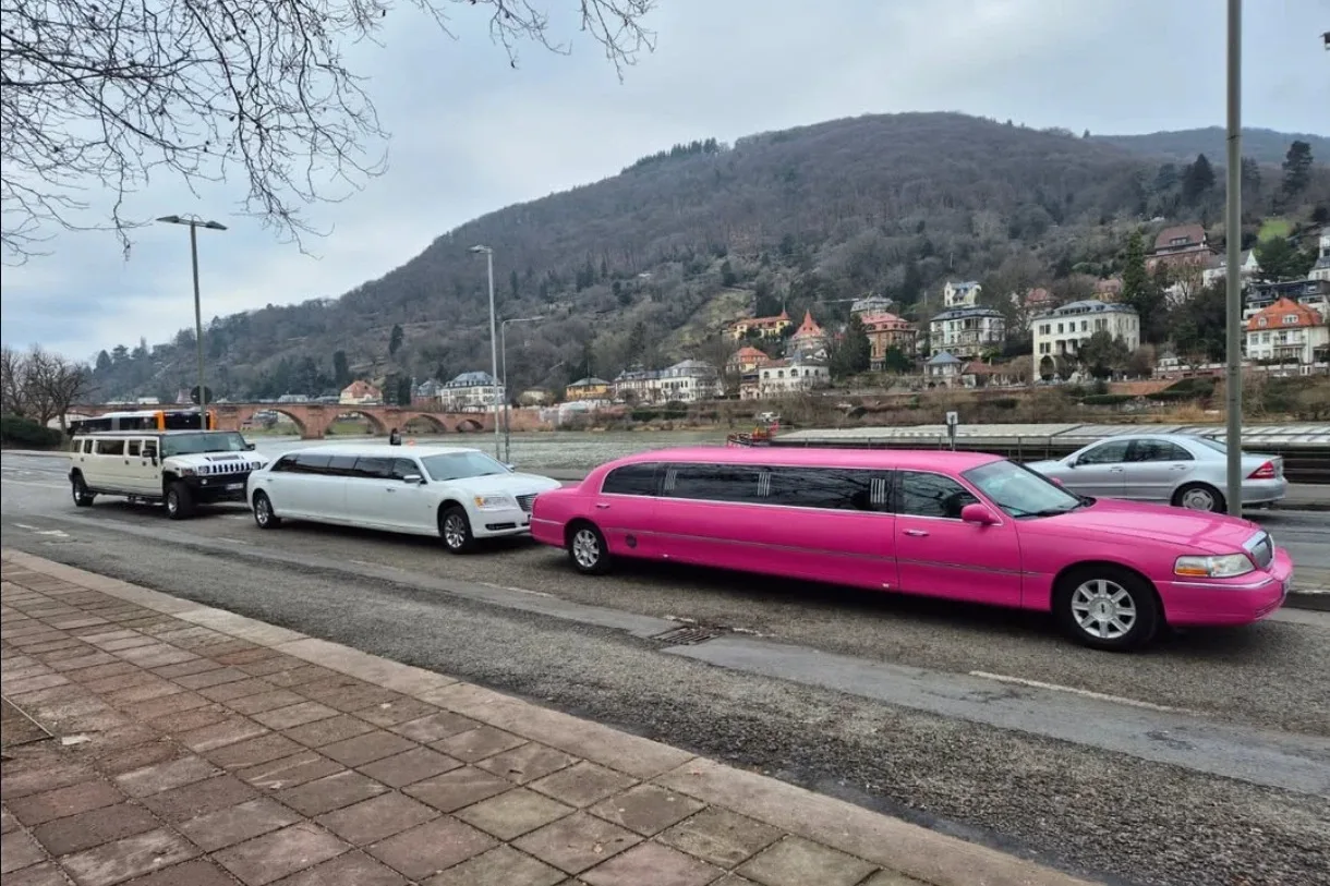 Hummer H2, Chrysler 300C und Lincoln Pink hintereinander am Flussufer vor bewaldeten Hügeln