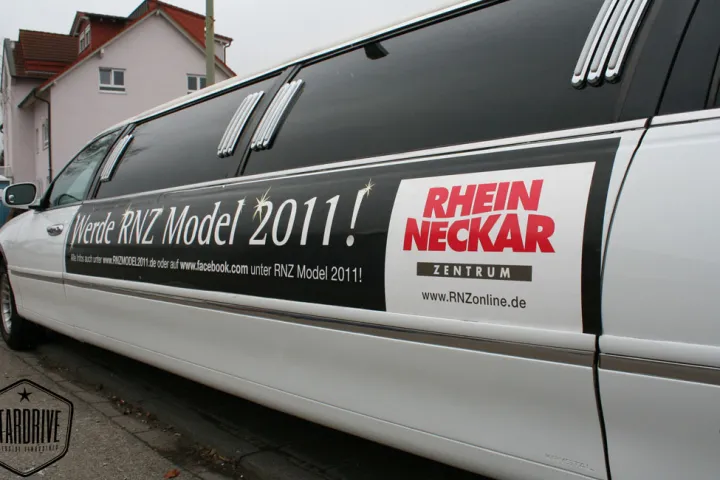 Weiße Limousine mit Werbebeklebung in der Seitenansicht