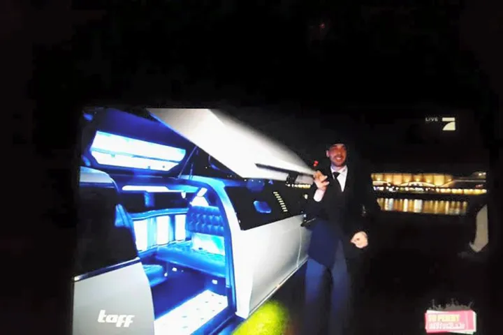 Innenraum einer Limousine mit blauer Beleuchtung und einem Gast