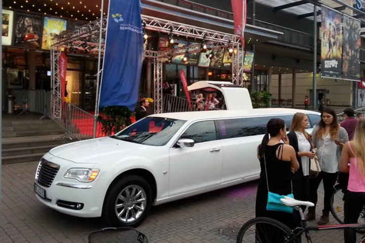 Weißer Chrysler 300C vor einem Veranstaltungsort