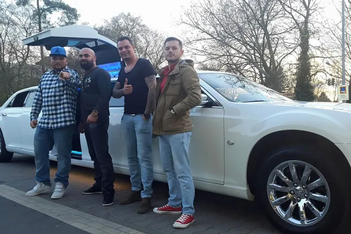 Gäste vor einer weißen Limousine