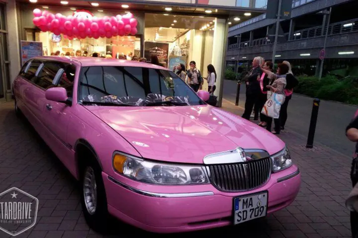 Pinke Limousine vor einer Eröffnungsfeier mit Ballondekoration