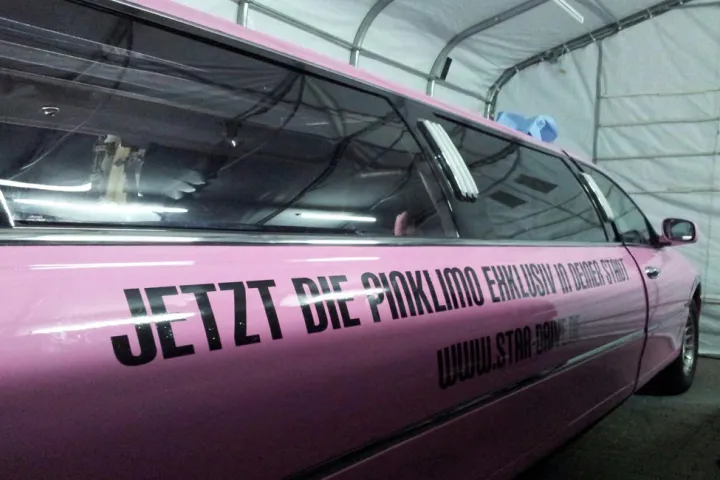 Pinke Limousine mit Werbeschriftzug