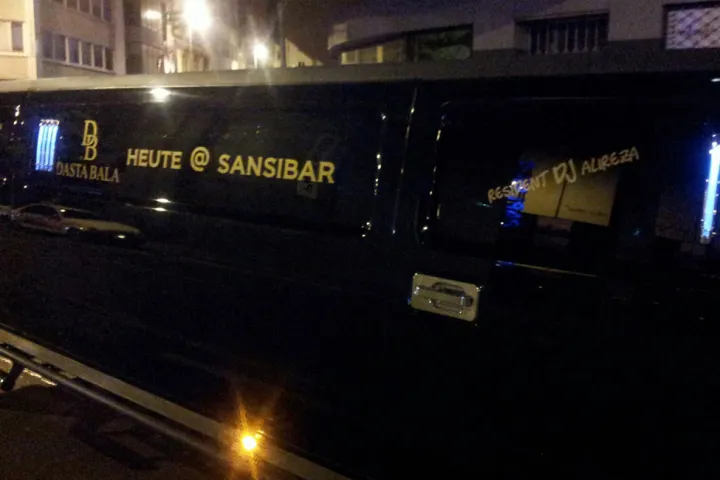 Dunkle Limousine vor einer Bar