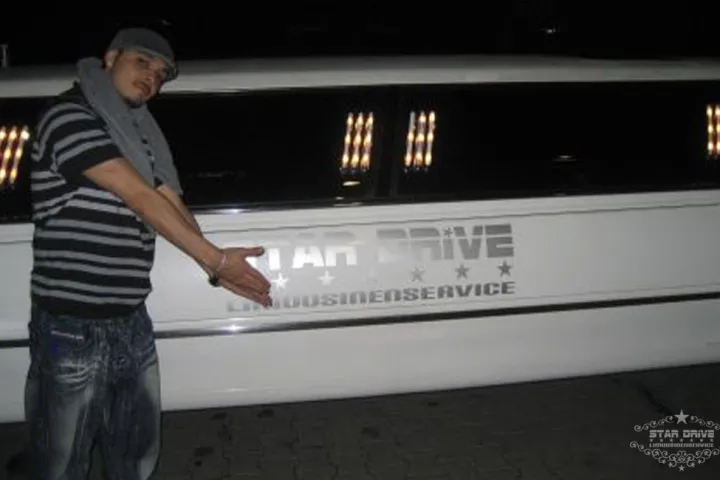 Mann vor einer weißen Limousine