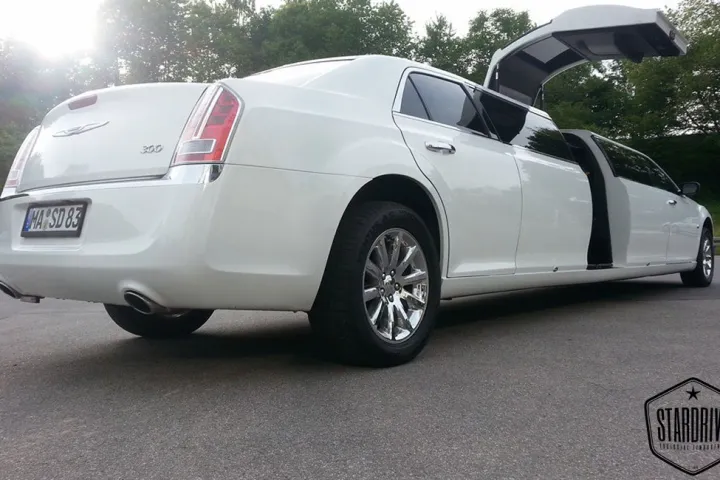 Weißer Chrysler 300C mit geöffneter Flügeltür in der Heckansicht