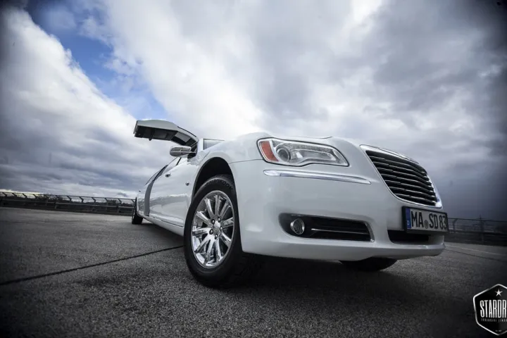 Weißer Chrysler 300C unter einem Gewitterhimmel
