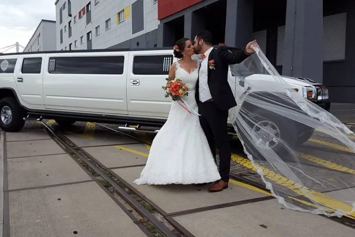 Brautpaar vor der weißen Hummer-Limousine