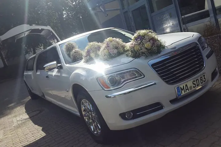 Weißer Chrysler 300C mit Blumenschmuck auf der Motorhaube