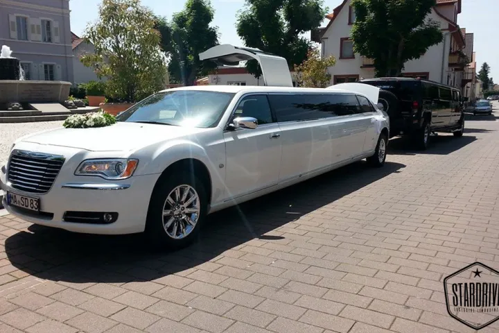 Weißer Chrysler 300C mit Hochzeitsschmuck auf der Straße