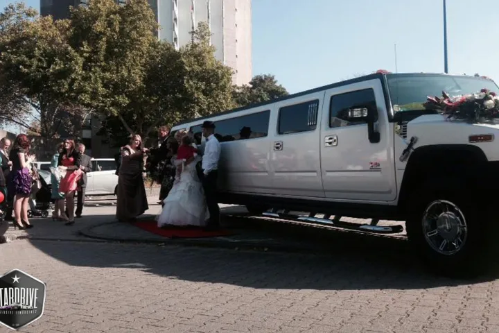 Braut vor der Hummer-Limousine