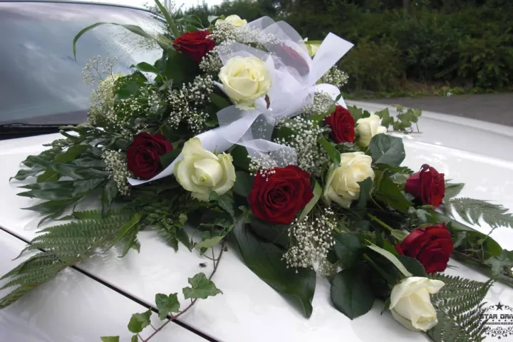 Rot-weißes Blumengesteck auf einer weißen Motorhaube