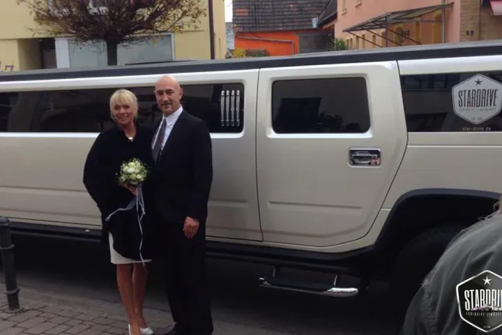 Paar vor der weißen Hummer-Limousine