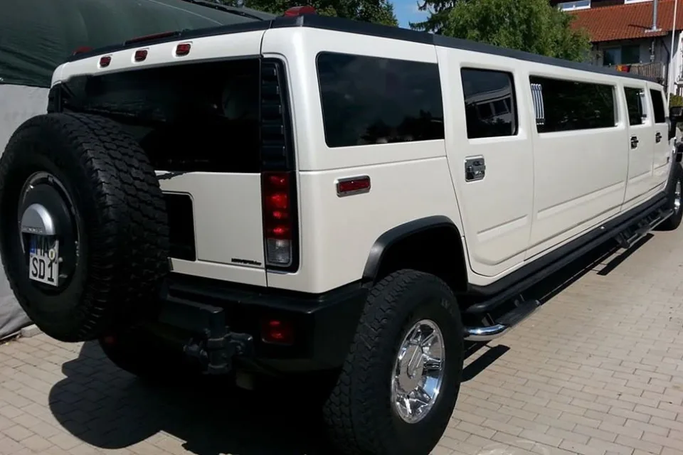 Weißer Hummer H2 von hinten mit Ersatzrad auf einem gepflasterten Platz