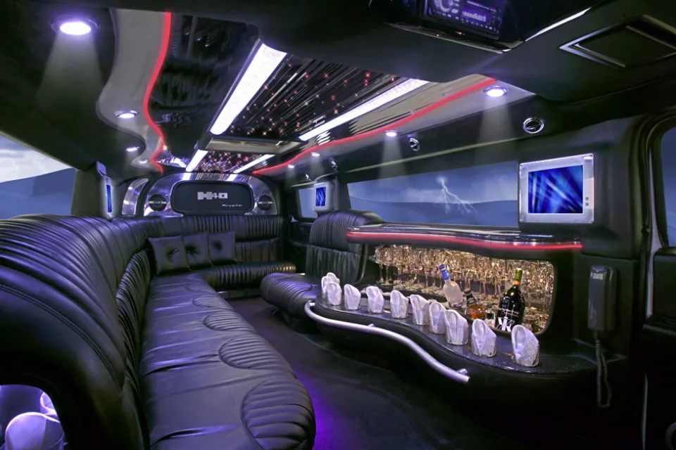 Innenraum des Hummer H2 mit schwarzen Ledersitzen, Sternenhimmel, Bar und Bildschirmen